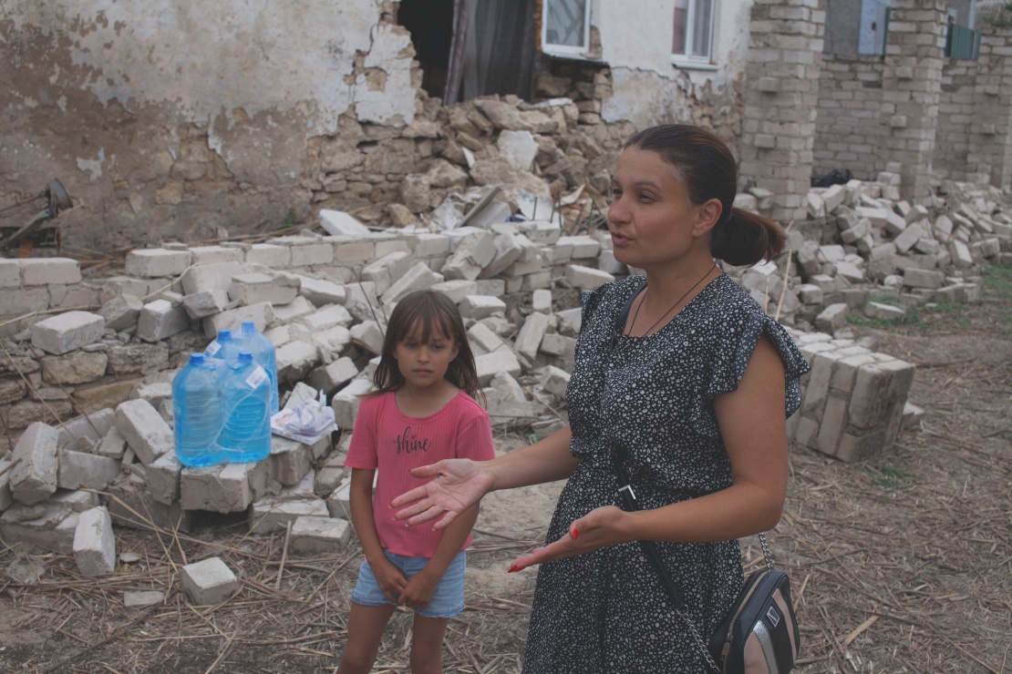 Tetyana Shapir and her daughter stand near a destroyed house in Afanasiivka. Now the family has finally started a new life