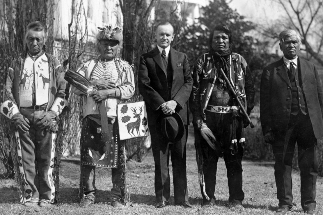 Президент США Калвін Кулідж з чоловіками племені осейдж після підписання Закону про громадянство індіанців, який надав усім корінним народам США рівні права з іншими громадянами, 1924 рік. 