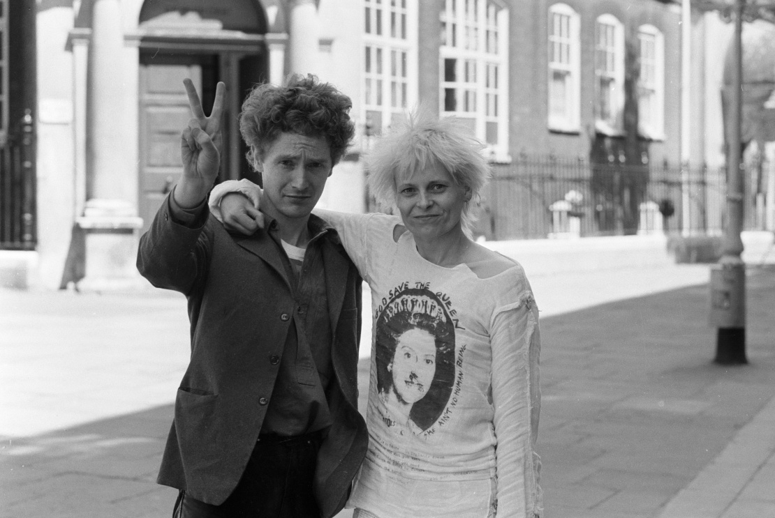Менеджер панк-гурту Sex Pistols Малкольм Макларен і Вів'єн Вествуд біля будівлі суду в Лондоні, після того як їх випустили під заставу за бійку в пабі, 1977 рік. На Вествуд футболка з принтом, який потім стане обкладинкою для альбому Sex Pistols.
