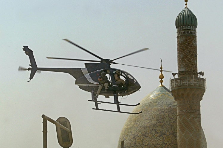 Гелікоптер охоронної фірми Blackwater летить над місцем, де вибухнула бомба біля посольства Ірану в центрі Багдаду, 5 липня 2005 року. Ціллю вибуху був саме конвой приватних охоронців.