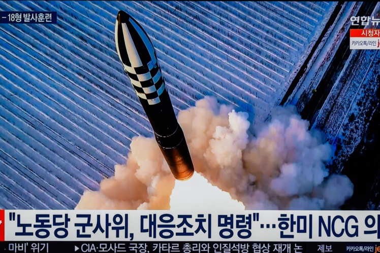 A television at a train station in South Korea shows the Hwasong-18 solid-fuel intercontinental ballistic missile launched by North Korea.