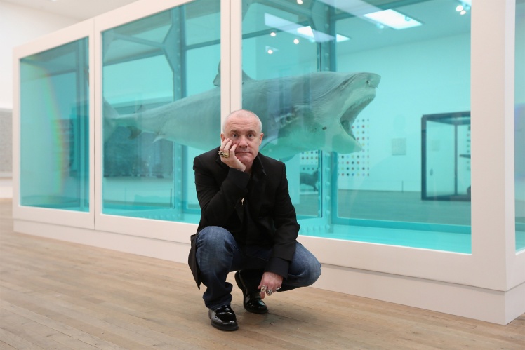 Damien Hirst next to his work "The Physical Impossibility of Death in the Mind of Someone Living" at a gallery in London, 2012.