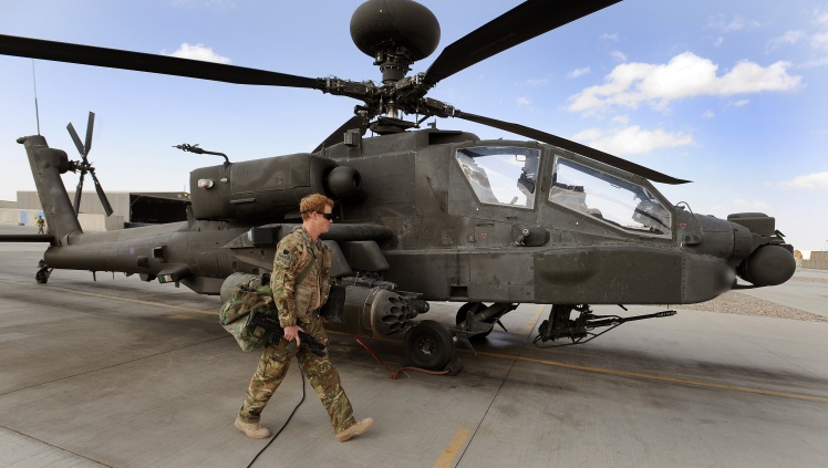 Prince Harry walks past an Apache helicopter at Camp Bastion in Afghanistanʼs Helmand province on October 31, 2012.