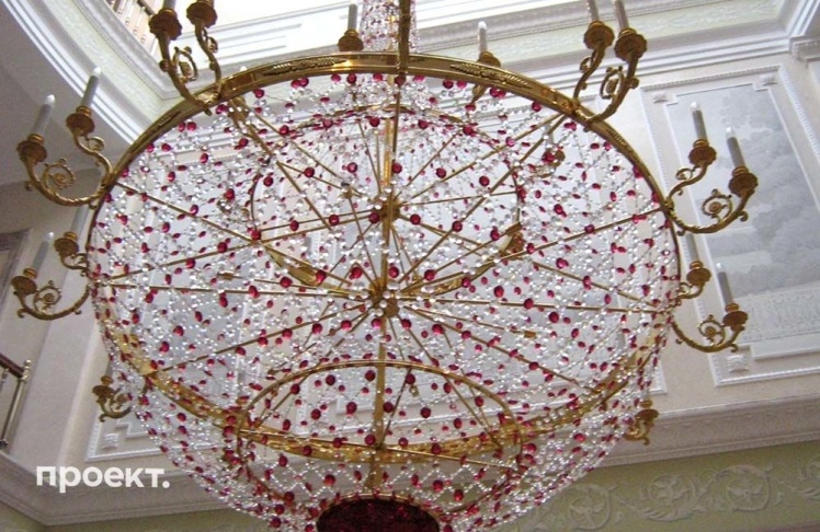 A chandelier hanging three stories high. It is decorated with rubies and gold leaf.