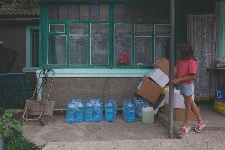 Злата допомагає мамі по господарству — волонтери щойно привезли родині воду.