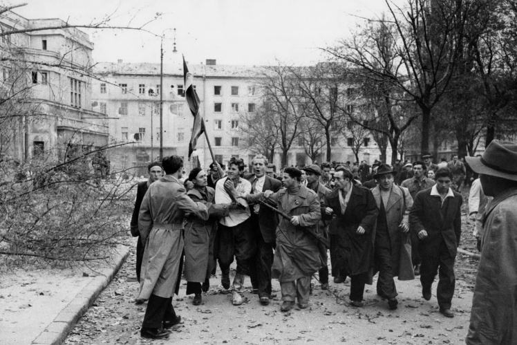 Співробітник угорської таємної поліції в оточенні протестувальників під час антикомуністичного повстання у Будапешті, кінець жовтня — початок листопада 1956 року.