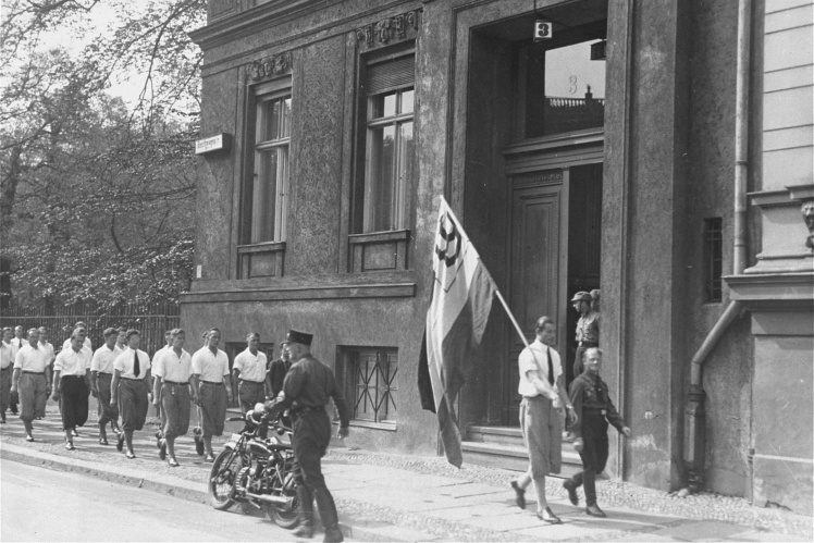 Студенти марширують перед будівлею Інституту сексуальних досліджень у Берліні перед тим, як вдертися туди, 6 травня 1933 року.
