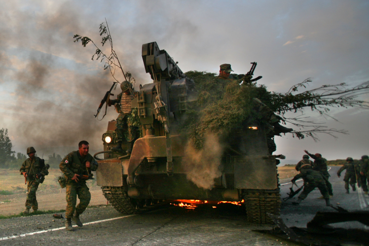 Georgian soldiers escape from burning armored vehicles on the road to Tbilisi near Gori, Georgia, on August 11, 2008.