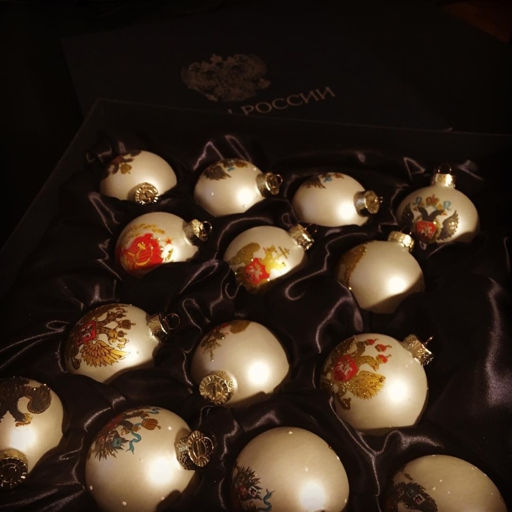 Photos of the Christmas balls. Literal translation of the caption: "This was just given to me as a gift. Christmas balls with the Russian coat of arms! Wonderful, arenʼt they? An award for a four-hour press conference."