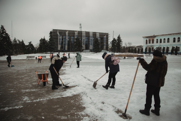 Комунальні працівники прибирають сніг на головній площі Ізюма.