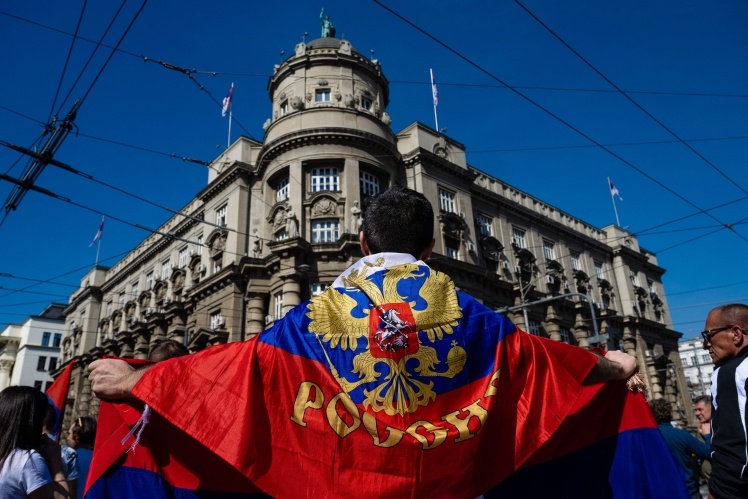 Чоловік тримає російський та сербський прапори під час так званої «попереджувальної акції протесту» проти плану ЄС та США про вихід із багаторічної ворожнечі між Сербією та Косово. Белград, 24 березня 2023 року.