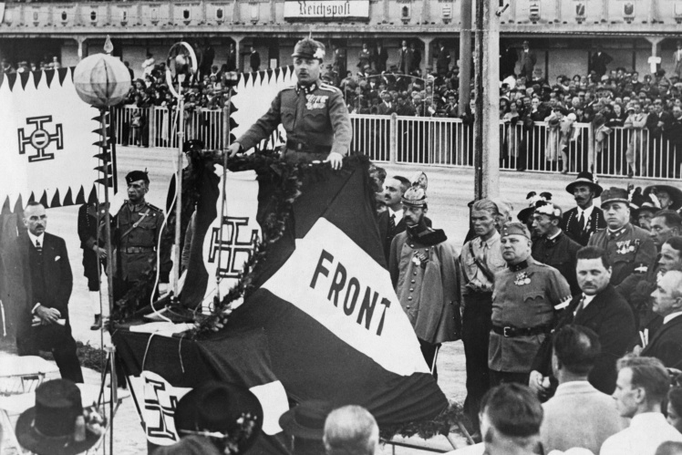 Дольфус виступає на мітингу у Відні на трибуні, прикрашеній символікою «Вітчизняного союзу», 1933 рік.