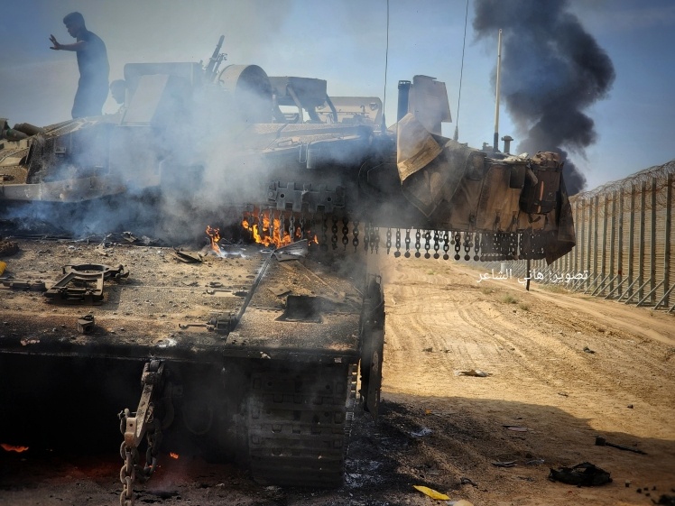 Hamas soldiers destroy an Israeli tank in Gaza City, October 7, 2023.