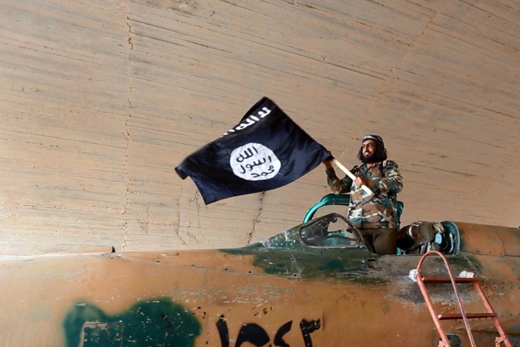 Бойовик «Ісламської держави» розмахує прапором, Ракка, Сирія, 2015 рік.