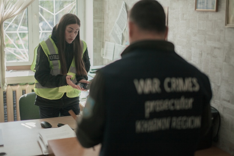 Investigator Yulia Brazhko and the prosecutor are preparing to read the suspect to the detained farmer.