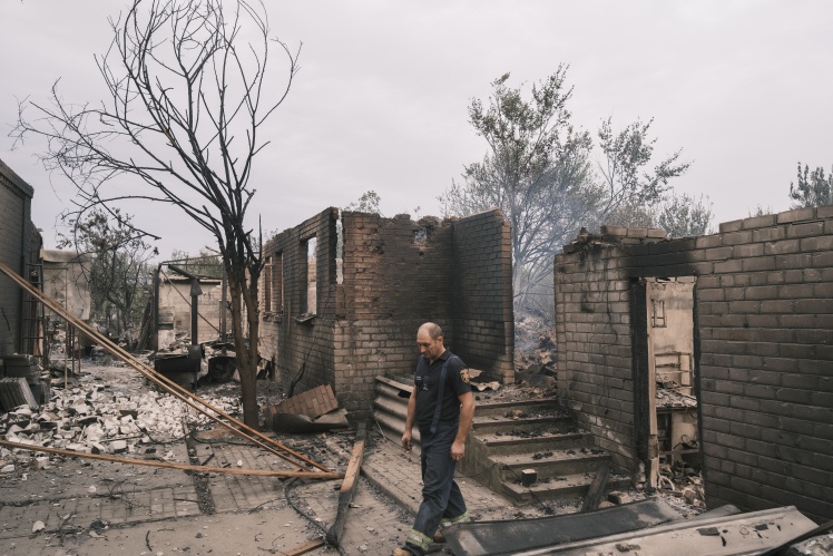 A rescuer in the middle of the ruins in Studenok.