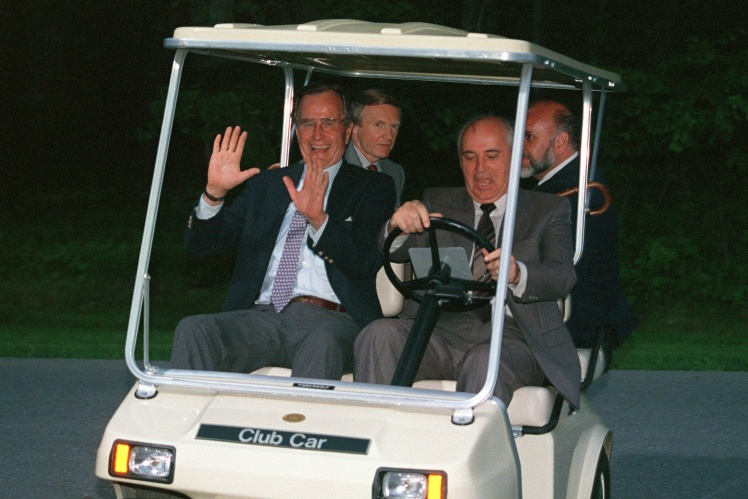 George W. Bush (left) and Mikhail Gorbachev ride a golf cart at Camp David, the US presidentʼs country residence, on June 2, 1990.