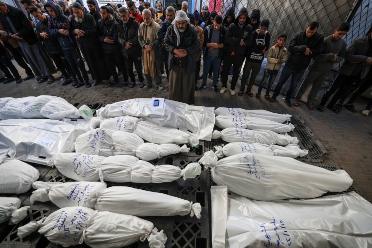Палестинці перед тілами загиблих після ізраїльського удару 18 січня 2024 року в місті Рафах.