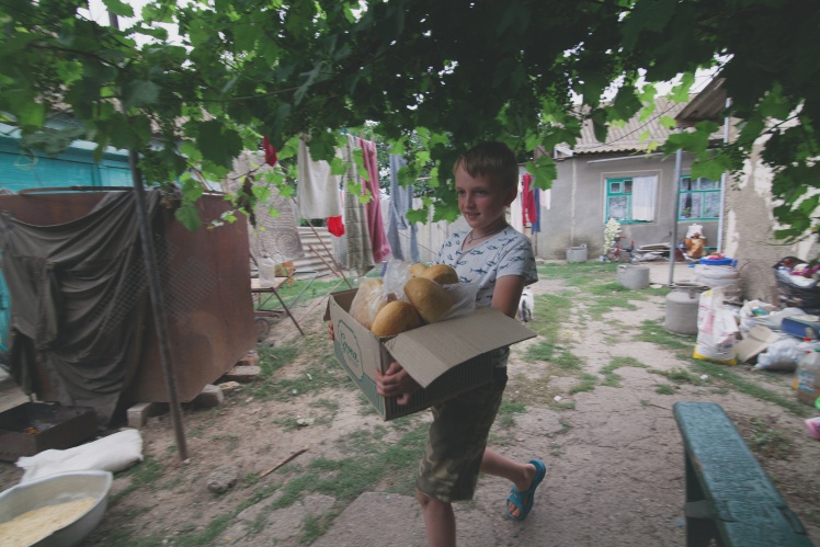 Tetyanaʼs nephew Serhiy carries loaves for all his relatives. After the flood, the boy lives in a small two-room house with his father, Tetyanaʼs family, and grandparents.
