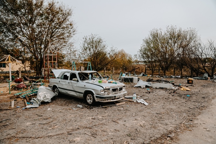 Дитячий майданчик біля магазину після удару ракетою. На передньому плані машина Миколи Гриба, тестя Дениса Козиря. Він теж загинув у кафе.