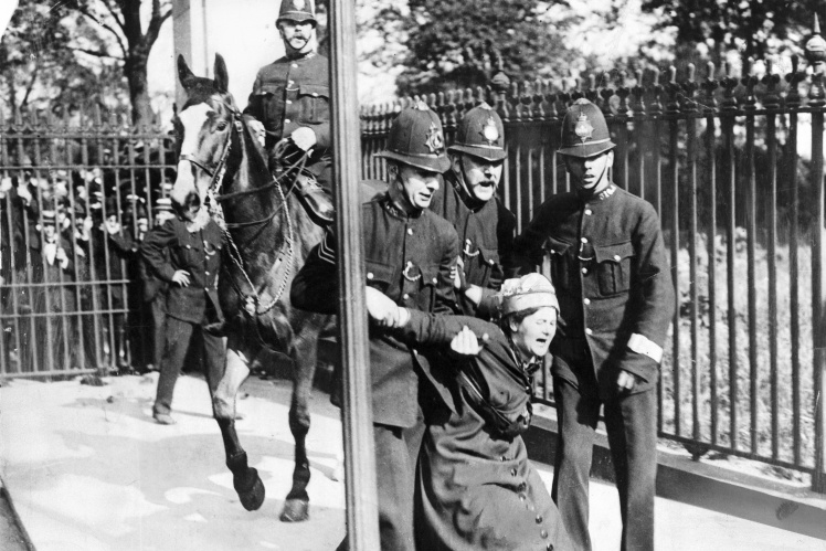 British policemen detain a female suffrage rally participant, 1910.