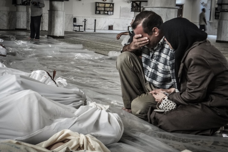 Parents cry over the body of their child killed in a chemical weapons attack in the Damascus suburb of Eastern Ghouta on August 21, 2013.