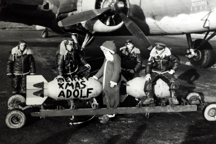 The crew of an American bomber carrying a bomb with the inscription "Merry Xmas Adolf", December 1942.