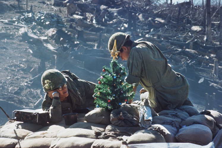 American soldiers during the Vietnam War rest near a small Christmas tree at their position, days after a massive assault by the North Vietnamese army, on December 25, 1967.