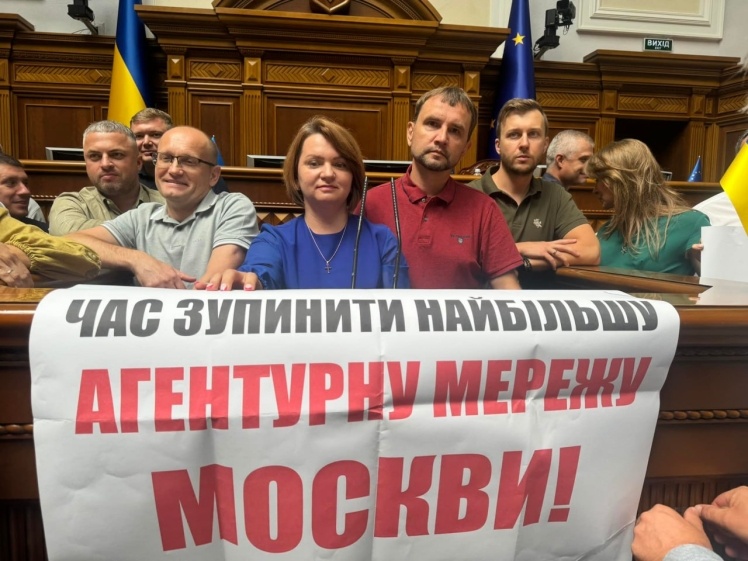 Deputies with placards block the tribune in the Rada.