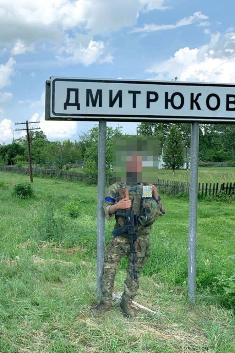 Ukrainian military against the road signs of captured Russian settlements in the Kursk region.