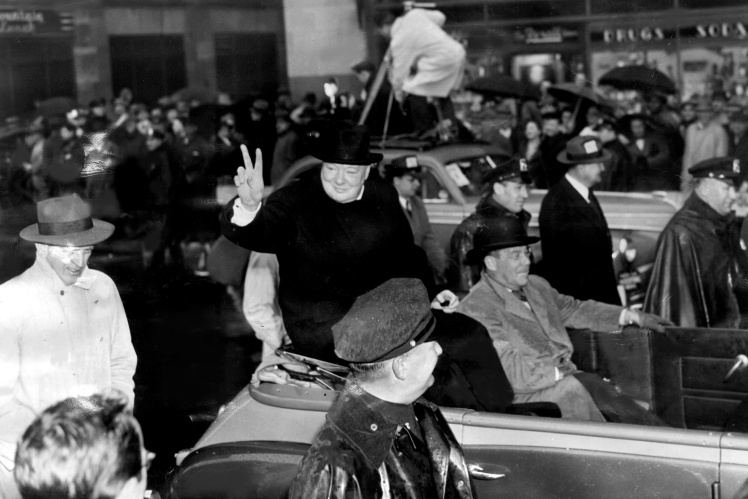 Churchill shows his famous "Victoria" gesture to people who greet him in New York on March 15, 1946.