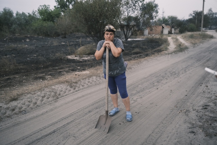 A student puts out the remains of a fire near the house.