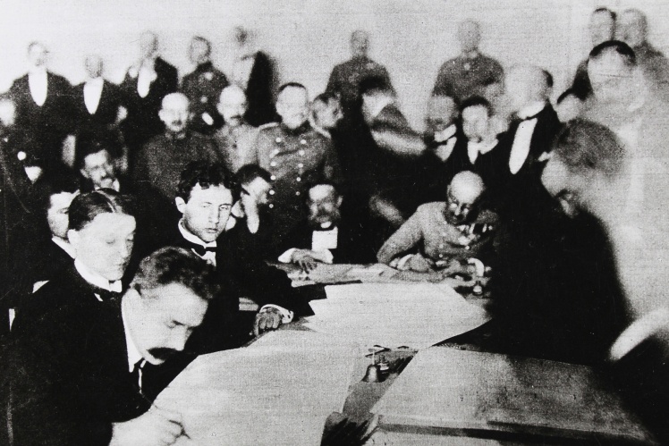 Член делегації УНР Микола Левитський (ліворуч) підписує Брест-Литовський мирний договір, 9 лютого 1918 року.