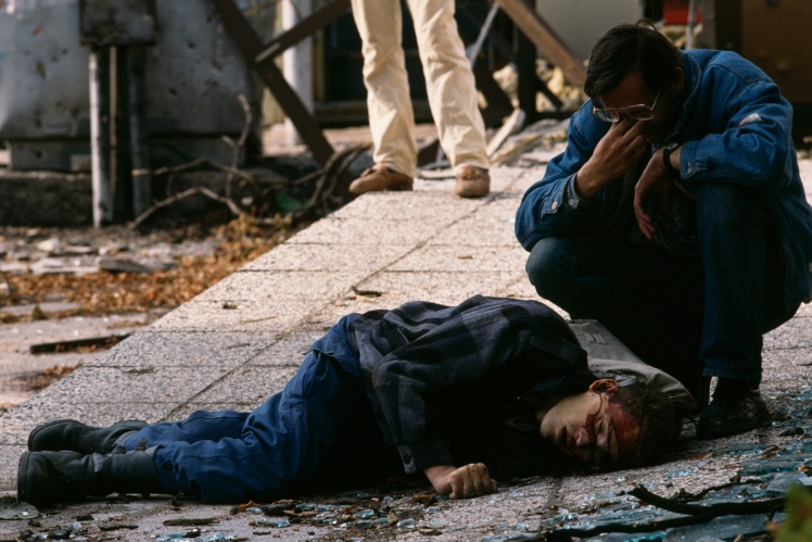 A man mourns the body of a civilian victim of the siege of Sarajevo, killed by a sniper. The siege of the city lasted from 1992 until the ceasefire in 1995.