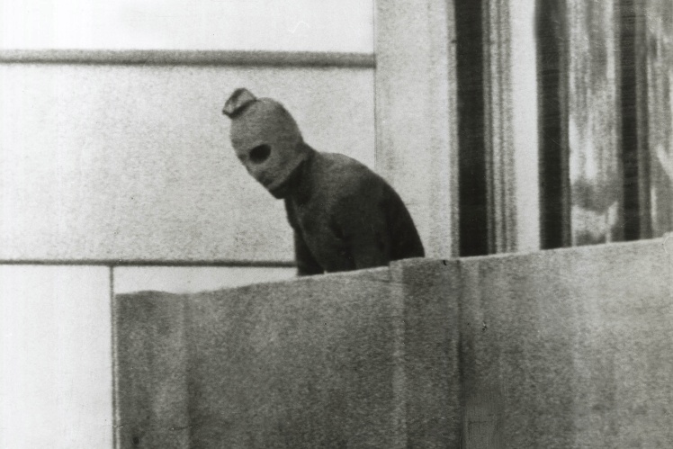 Один із терористів погрожує вбити заручників у відповідь на спробу штурму, 5 вересня 1972 року.
