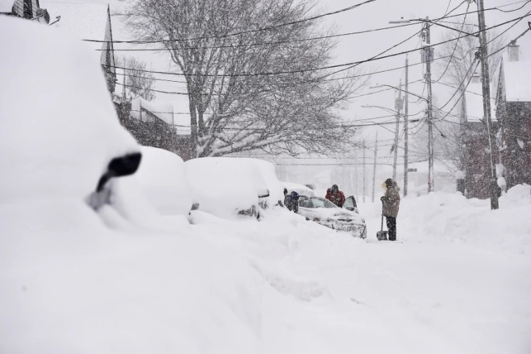 Сусіди разом розчищають автомобілі після снігопаду в місті Лекаванна, штат Нью-Йорк.