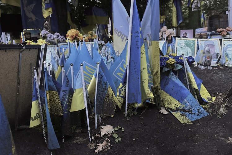 After every rainstorm, everything at the memorial is covered in dirt — the photos need to be wiped down and flags need to be cleared.