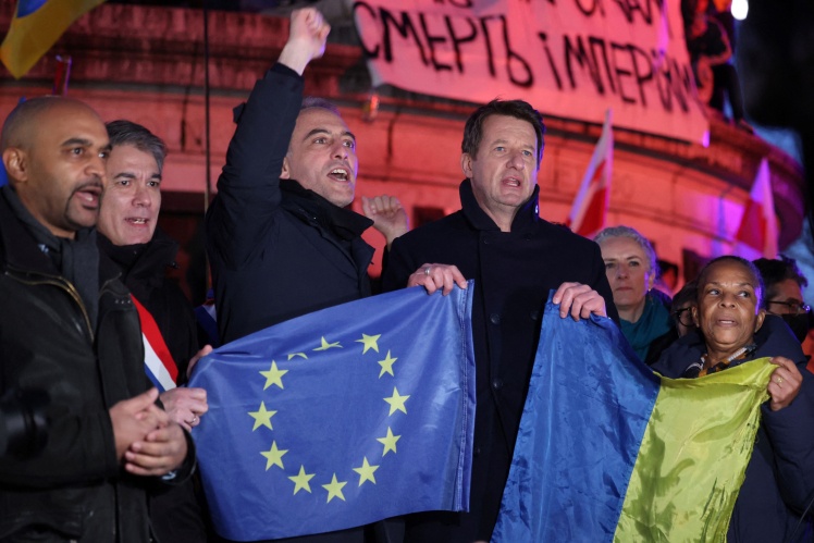 Акція на підтримку України в Парижі 24 лютого 2022 року. Рафаель Глюксманн — кандидат у президенти на виборах 2027 року — з піднятим кулаком, перед ним прапор ЄС.