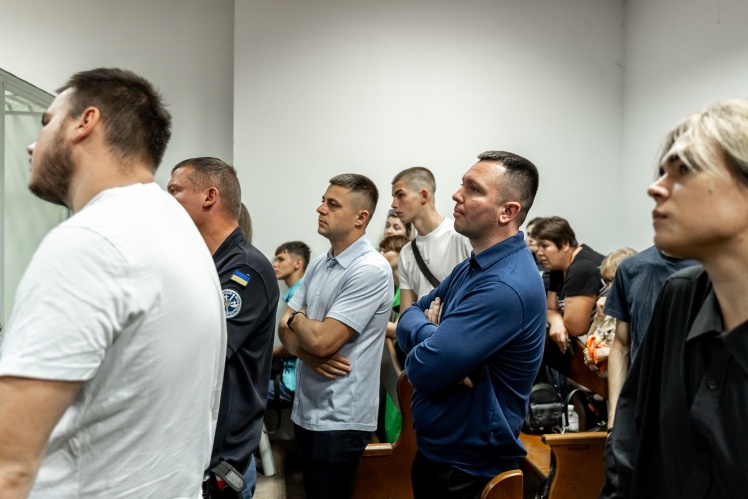 Зала суду затісна для групи підтримки Матерухіних. Багатьом не вистачає місця, люди стоять вздовж стін або у проході між лавами.