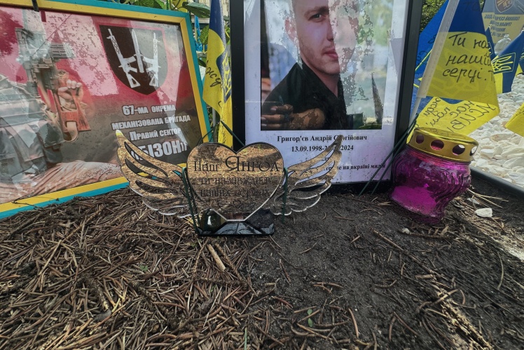 The memorial has many artificial flowers and figurines with inscriptions "to my beloved" and "our angel".