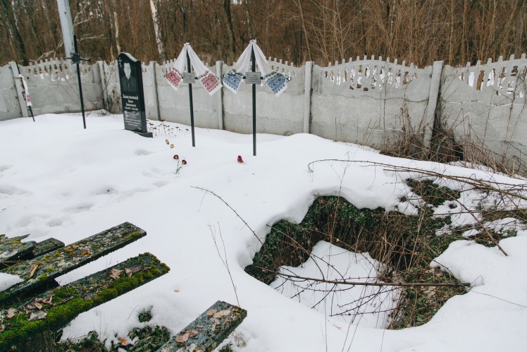 Near the pit are two graves with towels.