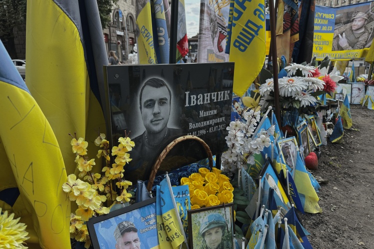 People bring portraits of the dead to the memorial in plywood frames, print them on metal, glass — as if they were in a cemetery.