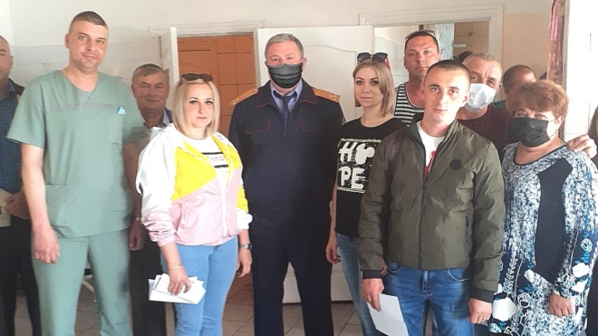 Російський слідчий фотографувався з лікарями без маски. Для публікації маску домалювали
