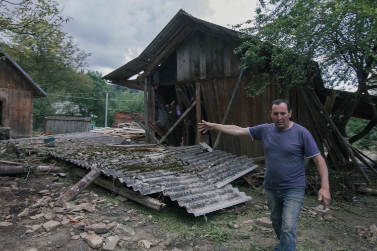 Житель Білих Ослав показує своє подвір'я. Він із родиною живе в кінці села, біля самих гір. Під час потопу земля зійшла, обрушившись із потоком води і зламаними деревами поряд із хатами.