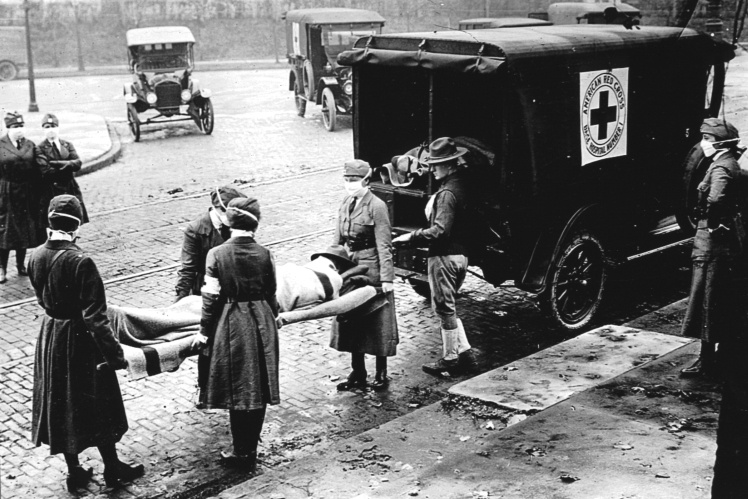 Патруль Червоного Хреста заносить пацієнта в карету швидкої допомоги під час епідемії іспанського грипу в Сент-Луїсі, штат Міссурі, жовтень 1918 року.