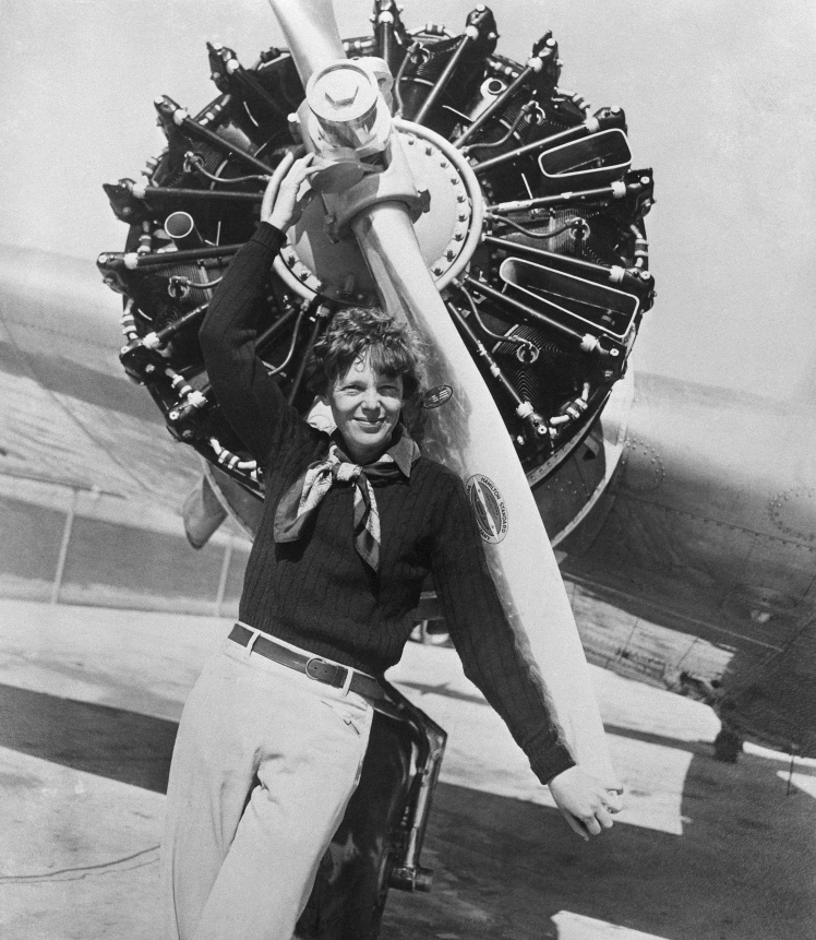 Амелия Эрхарт опирается на винт правого двигателя своего самолета.