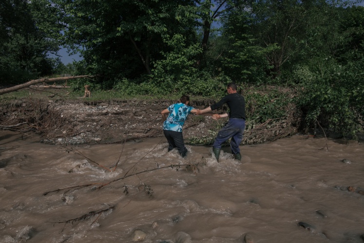 Местные жители добираются домой через ручей Кобылица. Мост через него разрушил потоп.