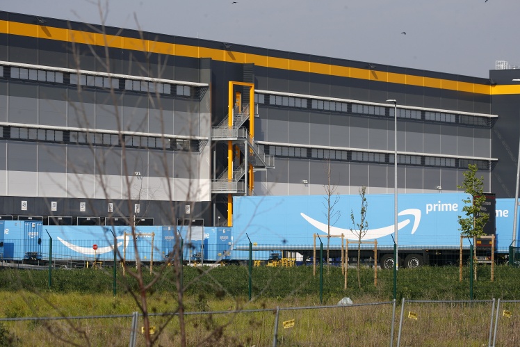 Грузовики с логотипом Amazon Prime Delivery, припаркованные возле логистического центра Amazon во французском городе Бретиньи-сюр-Орж; 13 апреля 2020 года.