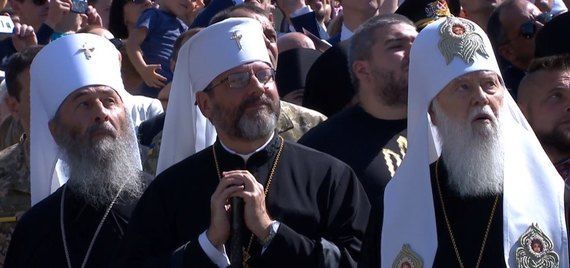 Священики дивляться в небо, де скоро з'являться гелікоптери.