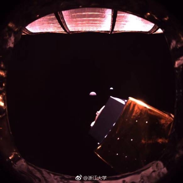 Фото зі супутника Queqiao. Більш великий коричневий об'єкт - зворотна сторона Місяця, невеликий блакитний - Земля.